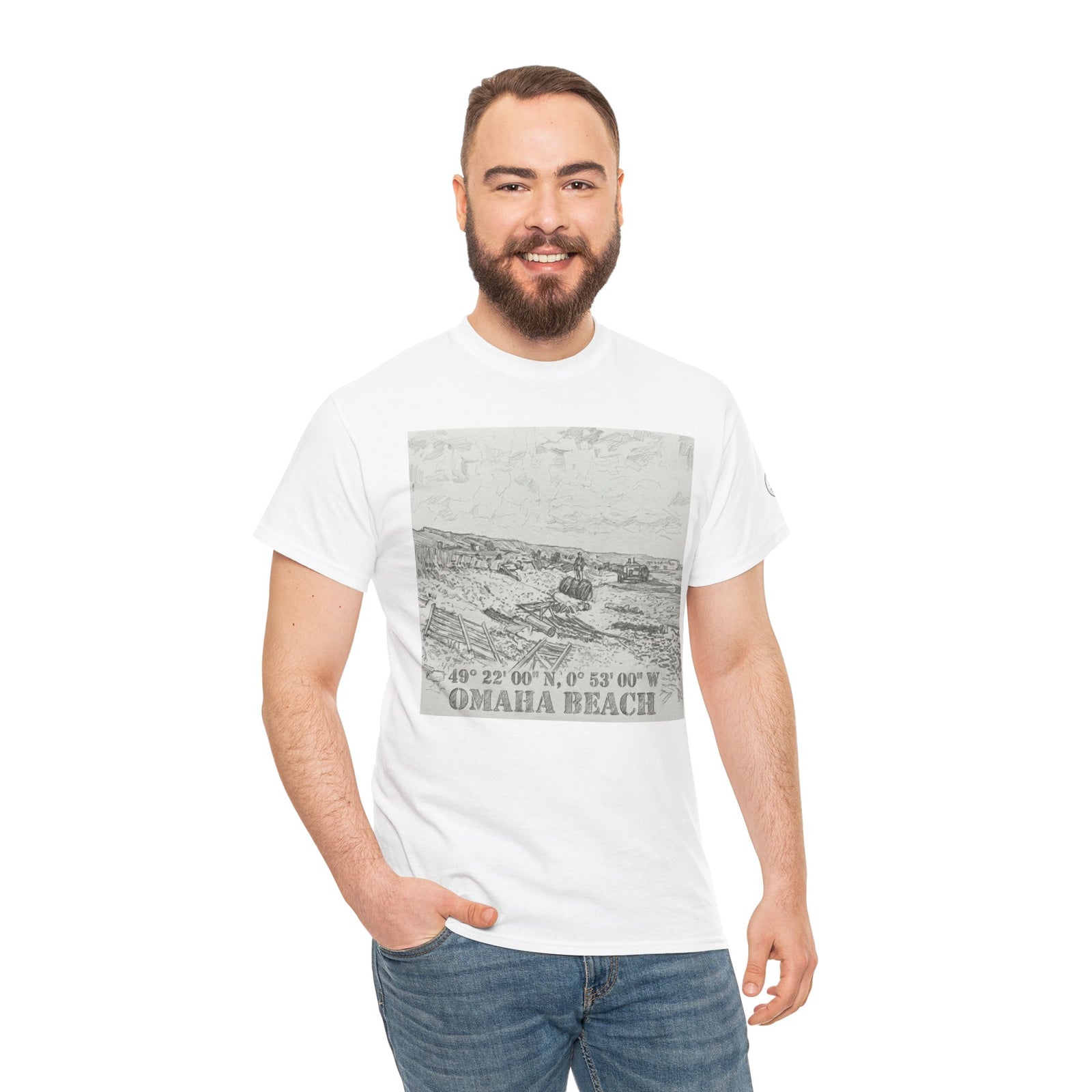 White graphic T-shirt by Veteran owned, featuring an Omaha Beach design with coordinates, styled with jeans.